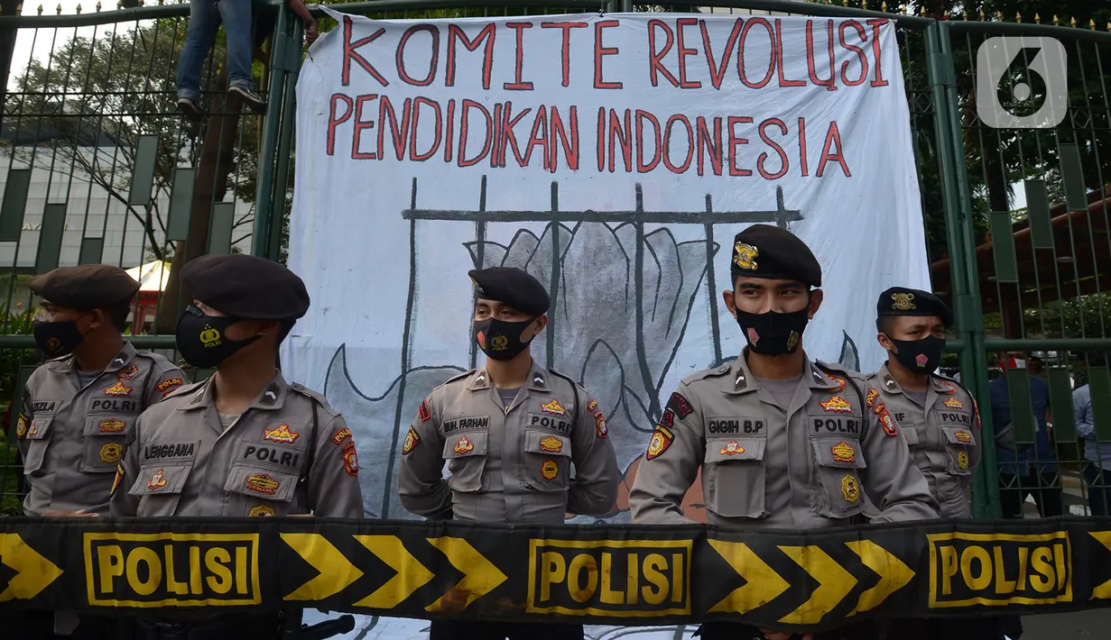 Polisi berjaga saat buruh, mahasiswa dan pelajar berunjuk rasa di depan gedung Kementerian Pendidikan dan Kebudayaan, Jakarta, Selasa (17/11/2020). Selain menuntut pencabutan UU Ciptaker, mereka juga meminta pemerintah menggratiskan biaya pendidikan selama pandemi Covid-19. (merdeka.com/Imam Buhori)