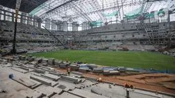 Pekerja menyelesaikan pemasangan rumput di lapangan utama Jakarta International Stadium (JIS), Selasa (26/10/2021). Rumput rekomendasi FIFA ini digadang-gadang mampu digunakan mencapai 1.000 jam pertandingan dalam setahun dan memiliki daya serap air yang baik. (merdeka.com/Iqbal S Nugroho)