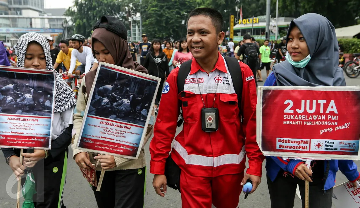 Sejumlah anggota PMI ikut serta dalam aksi di acara car free day, Bunderan HI, Jakarta, Minggu (6/3). Ratusan sukarelawan PMI meminta DPR untuk segera mengesahkan RUU Kepalangmerahan menjadi UU Kepalangmerahan pada tahun ini.(Liputan6.com/Yoppy Renato)