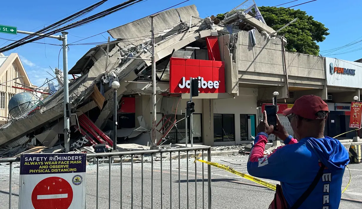 Warga mengambil foto bangunan yang runtuh akibat gempa bumi di General Santos, Filipina, Senin 8 Juni 2026. (AP Photo)