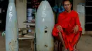 Seorang  biksu Buddha duduk di samping bom yang belum meledak dijatuhkan oleh pesawat-pesawat Angkatan Udara AS selama Perang Vietnam, di Provinsi Xieng Khouang, Laos (03/9). (REUTERS/Jorge Silva)