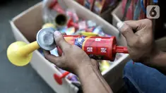Pedagang memainkan salah satu terompet berbahan plastik yang dijualnya di kawasan Pasar Gembrong, Jakarta, Minggu (29/12/2019). Berbeda pada tahun sebelumnya, penjualan terompet plastik jelang perayaan malam Tahun Baru 2020 lebih marak dibandingkan terompet kertas. (merdeka.com/Iqbal Nugroho)