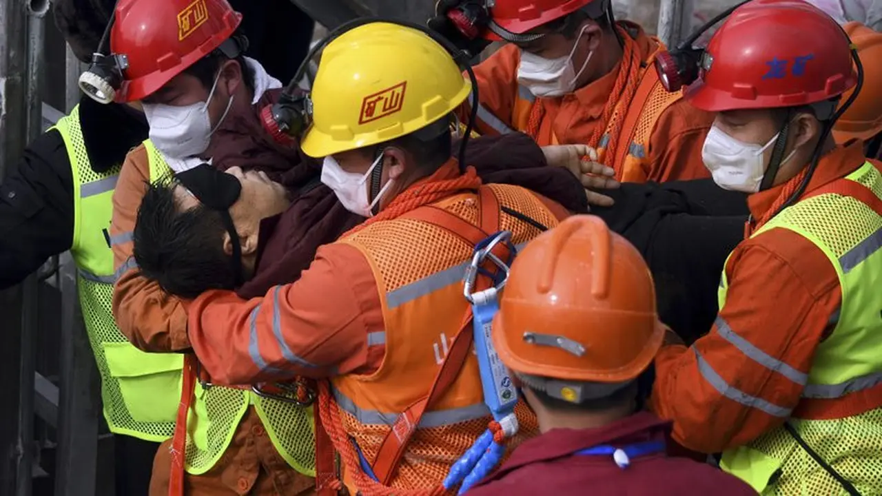 Tim penyelamat membawa seorang penambang yang terjebak di tambang ke ambulans di Kota Qixia di Provinsi Shandong, Tiongkok timur, Minggu, 24 Januari 2021.