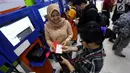 Petugas frontliner membantu calon penumpang membeli tiket di Stasiun Gambir, Jakarta, Minggu (21/4). PT KAI Daop 1 Jakarta mewajibkan petugas frontliner wanita dan pria mengenakan kebaya dan batik untuk menyambut Hari Kartini. (Liputan6.com/Johan Tallo)