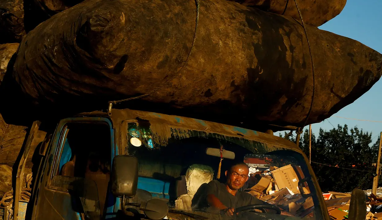 Seorang pengemudi mengendarai truk penuh karung di Beijing, Tiongkok, Sabtu (19/11). (REUTERS / Thomas Peter)