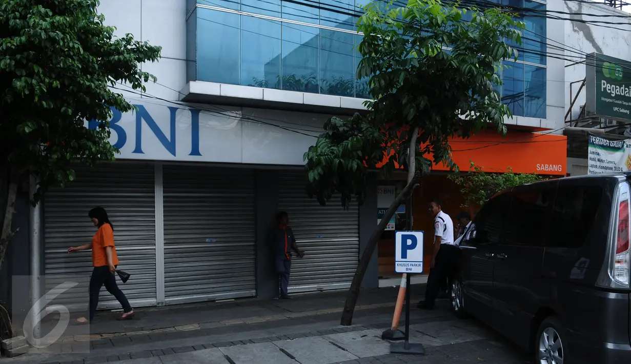 Sejumlah orang berdiri di depan perkantoran yang ditutup di Jalan Agus Salim Jakarta, Kamis (14/1). Pasca ledakan di pos polisi dekat Gedung Sarinah, sejumlah toko dan kantor di sekitar lokasi menghentikan aktivitasnya. (Liputan6.com/Helmi Fithriansyah)