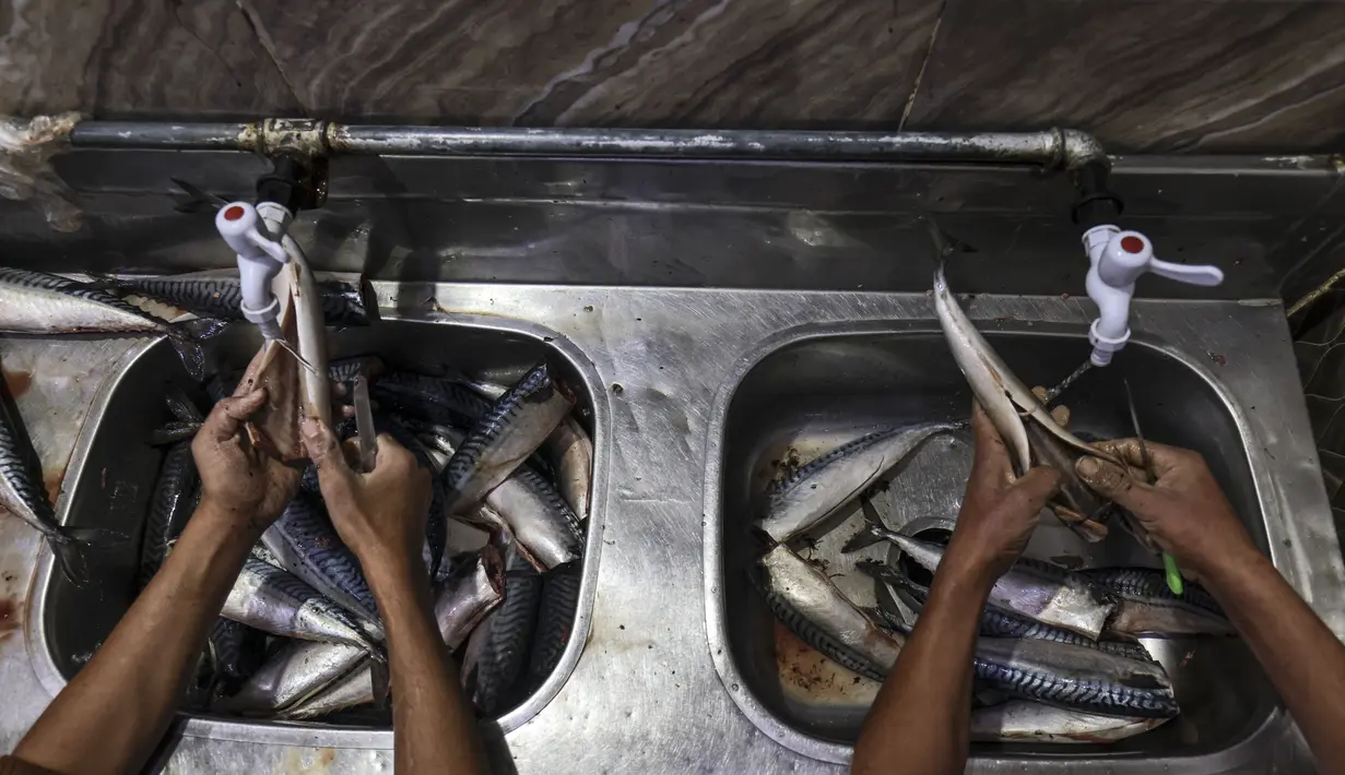 <p>Seorang pemuda Palestina bekerja di fasilitas pengasapan makarel saat ikan itu akan dijual jelang liburan Idul Fitri di Rafah di Jalur Gaza selatan (26/4/2022). Ikan asap makarel menjadi salah satu menu hidangan buka puasa dan Idul Fitri terfavorit bagi warga Gaza selama Ramadhan.(AFP/Said Khatib)</p>