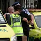 Polisi dan staf ambulans membantu seorang lelaki yang terluka dalam insiden penembakan di Masjid Al Noor, Christchurch, Selandia Baru, Jumat (15/3). Tiga korban penembakan adalah perempuan dewasa dan seorang lagi adalah gadis cilik. (AP Photo/Mark Baker)