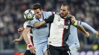 Bek Juventus, Leonardo Bonucci berebut bola dengan gelandang Atletico Madrid, Saul Niguez pada pertandingan Grup D Liga Champions di stadion Allianz di Turin, Italia (26/11/2019). Juventus menang tipis atas Atletico Madrid 1-0. (AP Photo/Antonio Calanni)