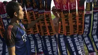 Pedagang atribut sepak bola merapihkan dagangannya saat berjualan pada laga perempat final Piala Presiden di Stadion Kanjuruhan, Malang, Sabtu (19/9/2015). (Bola.com/Vitalis Yogi Trisna)