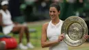 Petenis Spanyol, Garbine Muguruza berpose memegang trofi mengalahkan petenis AS Venus Williams pada final turnamen grand slam Wimbledon 2017 di London, Sabtu (15/7). Muguruza menang dua set langsung 7-5 6-0 atas Venus. (AP Photo/Tim Ireland)