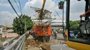 Alat berat memindahkan sampah ke truk pengangkut sampah di jembatan Kampung Melayu, Jakarta, Minggu (3/4/2016). Akibat luapan Ciliwung, tumpukan sampah menyangkut di jembatan Kampung Melayu. (Liputan6.com/Yoppy Renato)