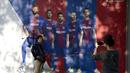 Fans berpose di dekat poster Gerard Pique yang dirusak di sebuah toko di luar stadion Camp Nou, Barcelona (3/10). Akibatnya Pique terancam dicoret dari segala kegiatan yang dilakoni La Furia Roja, julukan Timnas Spanyol. (AFP Photo/Josep Lago)
