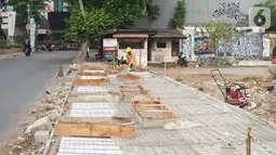 Pekerja menyelesaikan proyek revitalisasi trotoar di kawasan Kemang, Jakarta, Kamis (31/10/2019). Revitalisasi trotoar Kemang yang ditargetkan rampung pada November 2019 ini untuk memaksimalkan kenyamanan pejalan kaki dan mendongkrak aktivitas ekonomi di kawasan tersebut. (Liputan6.com/Angga Yuniar)