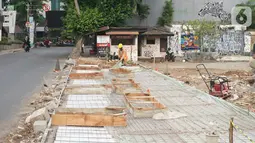 Pekerja menyelesaikan proyek revitalisasi trotoar di kawasan Kemang, Jakarta, Kamis (31/10/2019). Revitalisasi trotoar Kemang yang ditargetkan rampung pada November 2019 ini untuk memaksimalkan kenyamanan pejalan kaki dan mendongkrak aktivitas ekonomi di kawasan tersebut. (Liputan6.com/Angga Yuniar)