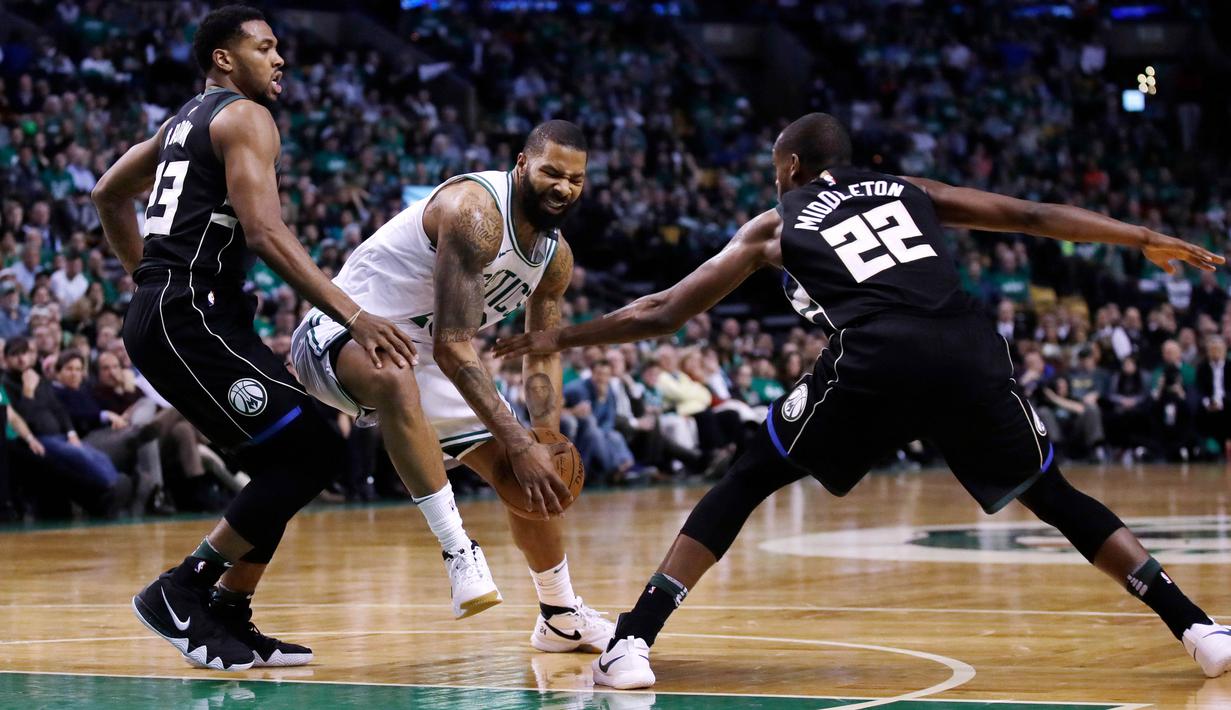 Pebasket Boston Celtics, Marcus Morris, berusaha melewati pebasket Milwaukee Bucks, Khris Middleton  dan Sterling Brown, pada gim kedua babak play off NBA di Stadion TD Garden, Rabu (18/4/2018). Celtics menang 120-106 atas Bucks. (AP/Charles Krupa)