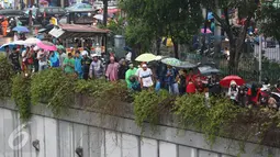 Warga menonton JPO yang roboh akibat hujan deras dan angin kencang di Jalan Raya Pasar Minggu, Jakarta Selatan, Sabtu (24/09). Kejadian itu menyebabkan arus lalin dari arah Pancoran dan sebaliknya mengalami kemacetan. (Liputan6.com/Immanuel Antonius)