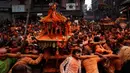 Warga menggotong kereta dewa saat perayaan sindoor Jatra festival di Bhaktapur, Nepal (15/4). Perayaan ini untuk menyambut datangnya musim semi dan Tahun Baru. (AP Photo/Niranjan Shrestha)