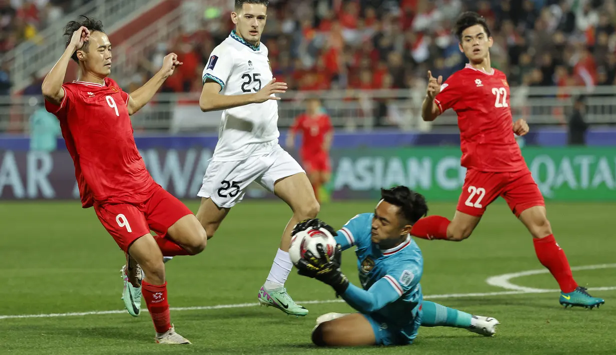 Kiper Timnas Indonesia, Ernando Ari Sutaryadi berhasil menangkap bola dari ancaman striker Vietnam, Nguyen Van Toan pada laga kedua Grup D Piala Asia 2023 di Abdullah Bin Khalifa Stadium, Doha, Qatar, Jumat (19/1/2024). (AFP/Karim Jaafar)
