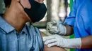 Seorang petugas kesehatan menyuntik seorang pria dengan suntikan vaksin Inavac untuk Covid-19 di kantor dinas kesehatan provinsi Jakarta pada 19 Desember 2023. (BAY ISMOYO/AFP)
