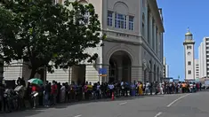 Orang-orang berbaris untuk mengunjungi kediaman resmi presiden Sri Lanka, beberapa hari setelah diserbu oleh pengunjuk rasa anti-pemerintah di Kolombo, Rabu (13/7/2022). Empat hari setelah kerumunan besar memaksa masuk ke Istana Sri Lanka, ribuan orang berkerumun untuk melihat kompleks yang luas itu. (Arun SANKAR / AFP)