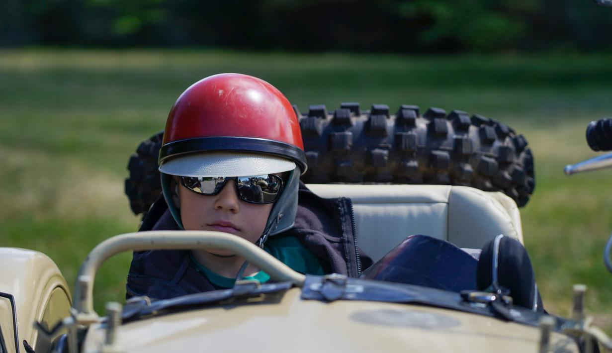 Seorang anak laki-laki duduk di sespan sepeda motor antik dalam sebuah festival yang diadakan di Karosta di Kota Liepaja, Latvia, pada 14 Juni 2020. (Xinhua/Janis Laizans)