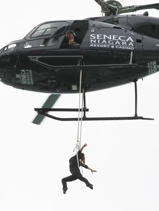 Nik Wallenda mengamati aksi akrobatik istrinya, Erendira Wallenda, dari atas sebuah helikopter, Kamis (15/6). Aksi bergelantungan di atas Air Terjun Niagara, New York menggunakan giginya itu berhasil memecahkan rekor. (AP Photo/Bill Wippert)
