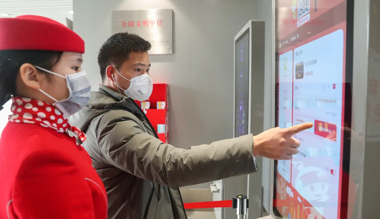 Wisatawan membeli tiket dengan mesin penjual tiket otomatis di Shanghai Oriental Pearl Tower, Shanghai, China, Kamis (12/3/2020). Shanghai Oriental Pearl Tower, Shanghai Jinmao Tower, dan Shanghai Tower sudah menerima wisatawan mulai 12 Maret 2020. (Xinhua/Ding Ting)