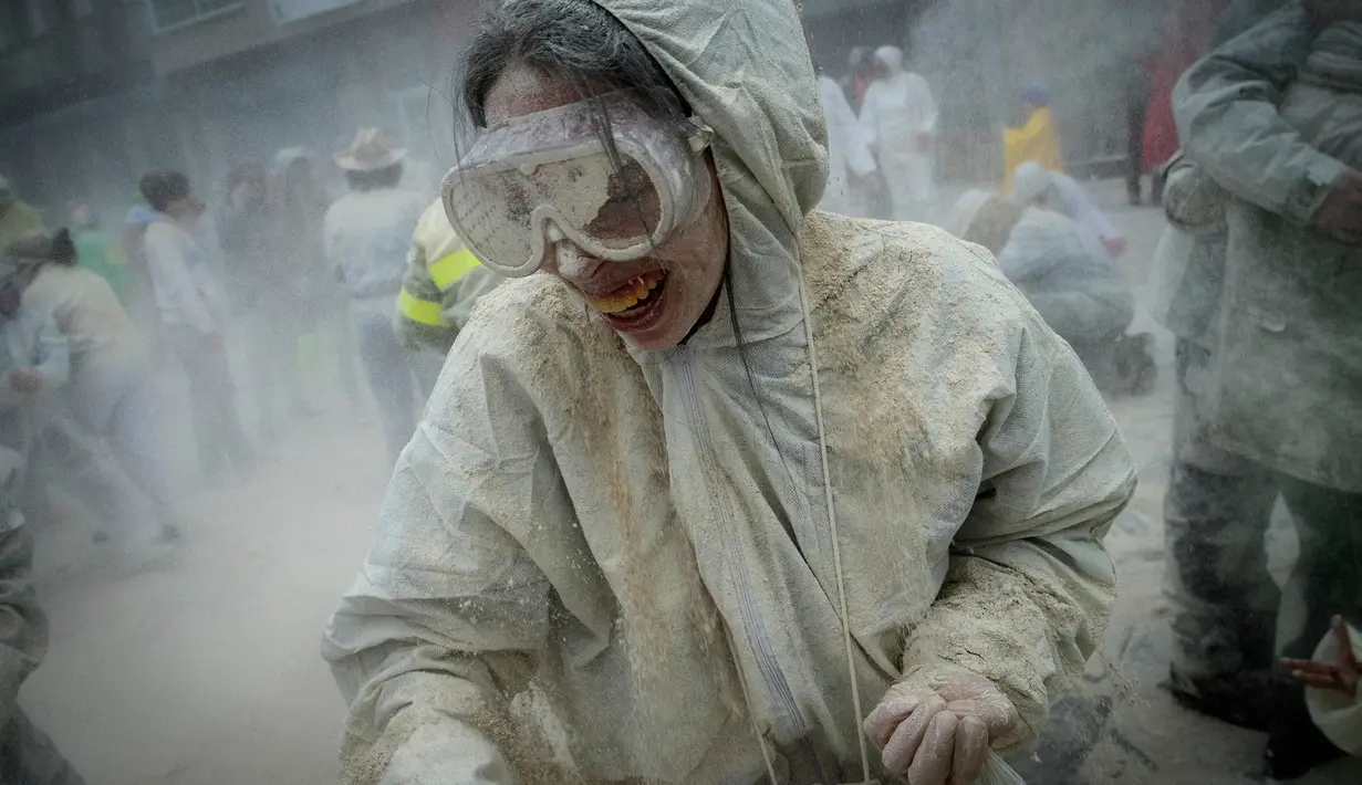 Seorang wanita tubuhnya penuh tepung saat mengikuti festival "Domingo Fareleiro" di desa Xinzo de Limia, Spanyol (21/1). Festival ini juga merupakan ritual pemurnian menjelang masa prapaskah. (AFP/Miguel Riopa)
