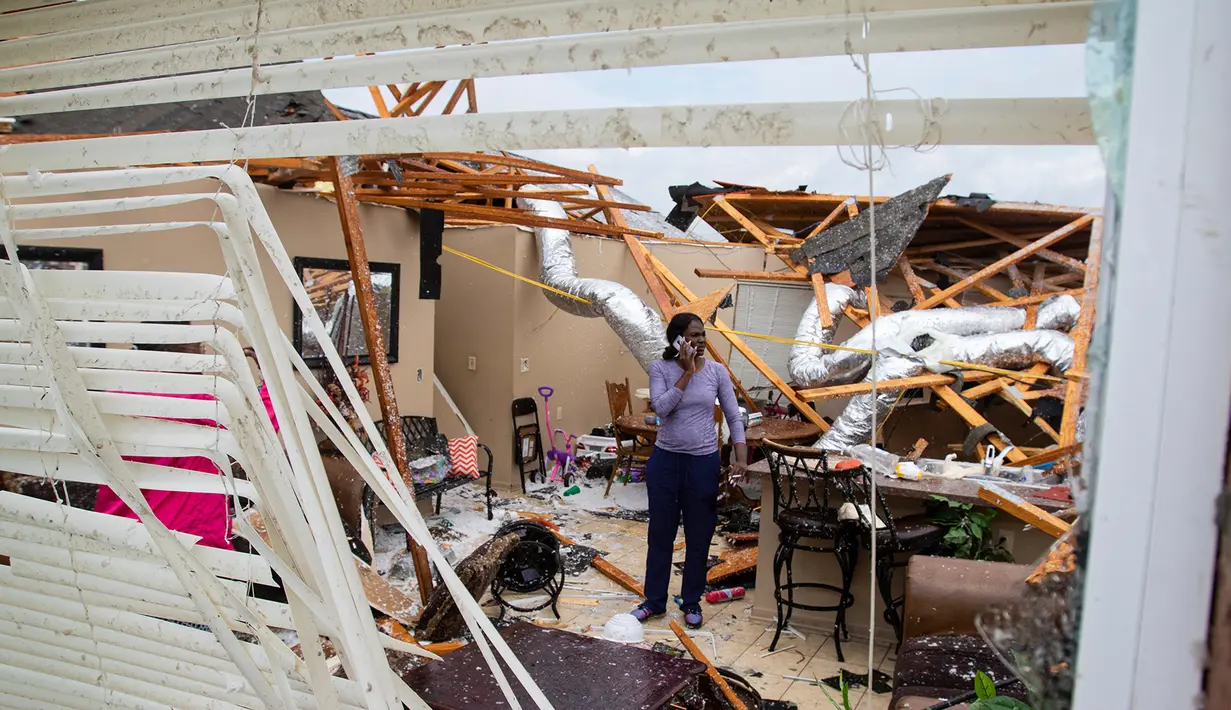 Seorang warga berada di rumah yang rusak akibat dihantam Tornado di Monroe, La, Minggu (12/4/2020). Layanan Cuaca Nasional (NWS) AS sebelumnya mengeluarkan peringatan darurat ke level tertinggi karena tornado berpotensi menyebabkan kehancuran yang parah. (Nicolas Galindo/The News-Star via AP)