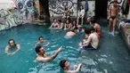 Wisatawan berendam di kolam air panas di ujung selatan Dataran Tinggi Golan yang dianeksasi Israel, dekat perbatasan dengan Yordania, 1 Maret 2019. Kolam dengan air panas itu berasal dari aliran pipa pengeboran di Lembah Hula. (MENAHEM KAHANA/AFP)