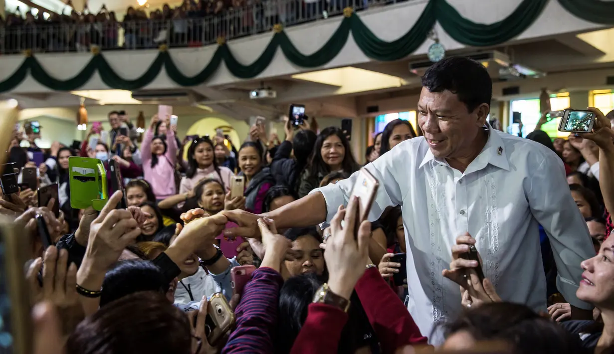 Peniru Presiden Filipina Rodrigo Duterte, Cresencio Extreme bersamalan dengan jemaat gereja di pusat Hong Kong, 3 Februari 2019. Suasana misa mendadak riuh setelah kedatangan dua sosok yang mirip dengan Duterte dan Kim Jong Un. (ISAAC LAWRENCE/AFP)