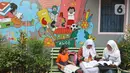 Pelajar membaca buku di Kampung Literasi RW 08, Jatipulo, Palmerah, Jakarta Barat, Kamis (30/1/2020). Kampung Literasi ini memiliki 5 kotak berisi beragam buku yang ada di sejumlah titik, berbekal konsep kejujuran disebar di sepanjang kampung. (Liputan6.com/Herman Zakharia)