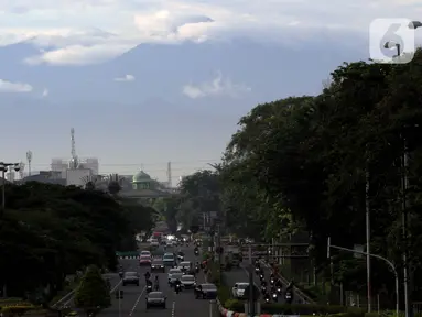 Kawasan gunung Gede-Pangrango terlihat samar menjadi latar belakang pemandangan di Jalan Benyamin Sueb, Kemayoran, Jakarta, Kamis (18/2/2021). Jika cuaca cerah, kawasan gunung Gede-Pangrango bisa terlihat dengan jelas dari atas jembatan layang Jalan HBR Motik. (Liputan6.com/Helmi Fithriansyah)
