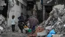 Ribuan orang harus mengantre berjam-jam untuk mendapatkan air dalam jumlah yang sangat sedikit. Tampak dalam foto, warga Palestina mengumpulkan air dari selang selama hujan deras di kawasan Sheikh Radwan, Kota Gaza, Jumat 14 November 2025. (AP Photo/Jehad Alshrafi)