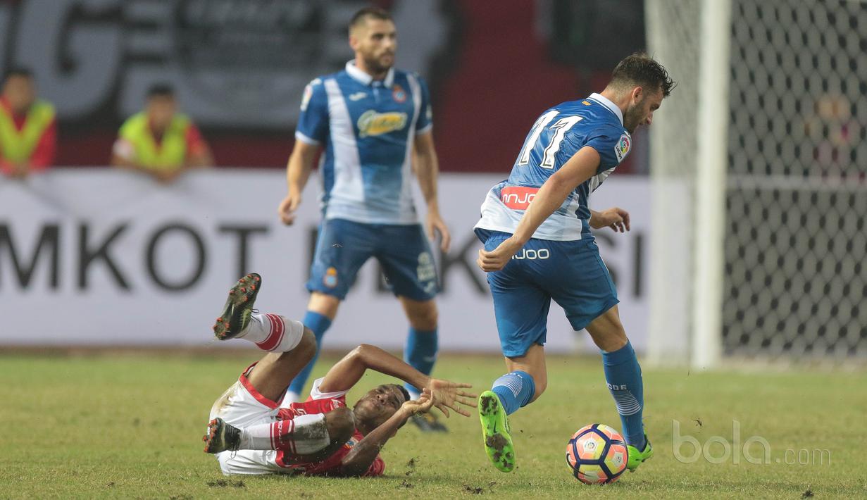Pemain Persija Jakarta, Pandi Lestaluhu terjatuh saat berduel dengan pemain RCD Espanyol, Leonardo Baptista Esteban pada laga persahabatan di Stadion Patriot, Bekasi, (19/7/2017). Persija kalah 0-7. (Bola.com/Nicklas Hanoatubun)