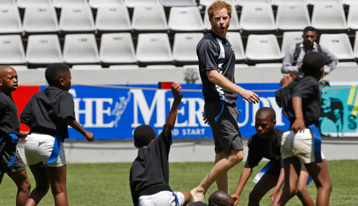 Pangeran Harry  berbincang dengan anak - anak di Durban , Afrika Selatan, Selasa (1/12). Harry dan  Pangeran Lerotholi Seeiso membuat organisasi amal yang bernama Sentebale. (REUTERS/Rogan Ward) 