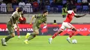 Gelandang Arsenal, Thomas Partey membawa bola dari kejaran gelandang AC Milan, Yacine Adli dan Sandro Tonali selama pertandingan Dubai Super Cup 2022 di di stadion al-Maktoum di Uni Emirat Arab (13/12/2022). Arsenal menang tipis atas AC Milan dengan skor 2-1. (AFP/Karim Sahib)
