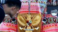 Seorang pria memegang burung Garuda Pancasila di mobil bercorak Ulos Mandailing yang akan digunakan acara ngunduh mantu Kahiyang-Bobby di Medan, Senin (20/11). (Liputan6.com/JohanTallo)