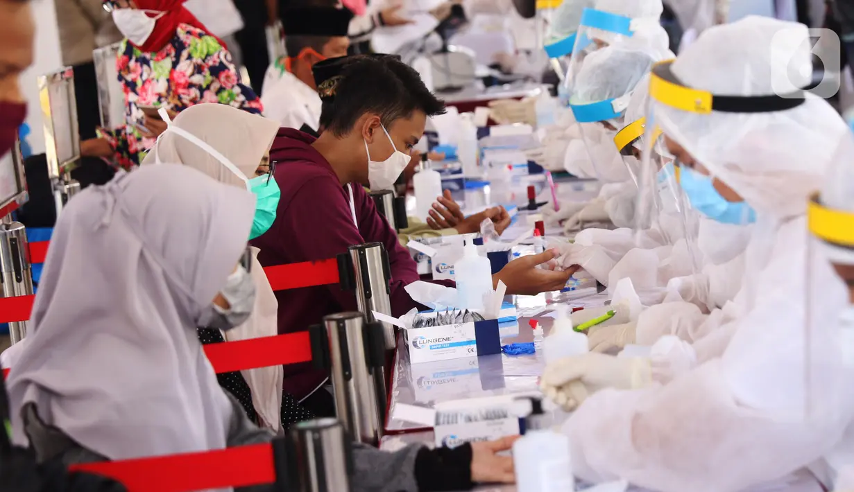 Petugas Medis mengambil sampel darah warga saat rapid test massal di Kota Tangerang, Banten, Sabtu (30/5/2020).  Badan Intelijen Negara (BIN) menggelar tes diagnostik cepat (rapid rest) massal kepada warga Ciledug sebagai salah satu upaya pengendalian transmisi COVID-19. (Liputan6.com/Angga Yuniar)