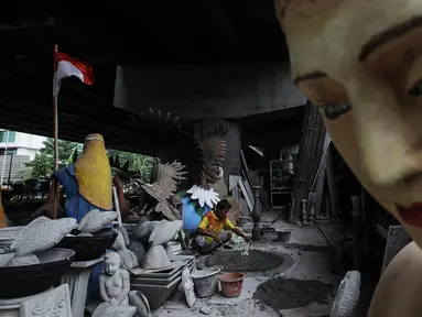 Perajin membuat patung berbahan dasar batu alam di Sanggar Dunia Batu Alam, Jakarta, Senin (5/12/2020). Sebelum pandemi Covid-19 perajin batu alam mengaku mendapatkan omzet Rp200 juta - Rp300 juta sebulan, namun kini hanya mampu mengantongi Rp30 juta - Rp50 juta sebulan. (merdeka.com/Imam Buhori)