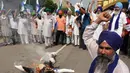 Dalam aksinya, para petani membakar membakar patung Perdana Menteri India Narendra Modi dengan logo KTT G20 India. (Narinder NANU/AFP)
