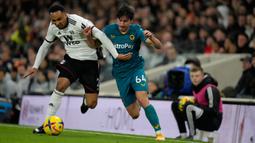 Pemain Fulham Kenny Tete (kiri) bersaing memperebutkan bola dengan pemain Wolverhampton Wanderers Hugo Bueno pada pertandingan sepak bola Liga Inggris di Stadion Craven Cottage, London, Inggris, 24 Februari 2023. Pertandingan berakhir imbang 1-1. (AP Photo/Kirsty Wigglesworth)