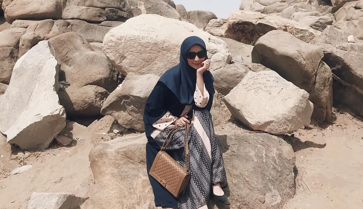 Pesona Citra Kirana dengan balutan hijab dan kacamata saat berfoto di bukit Jabbal Rahmah, Mekkah. Jabal Rahmah merupakan tempat bertemunya Adam dan Hawa setelah lama berpisah. (Liputan6.com/IG/ @citraciki)