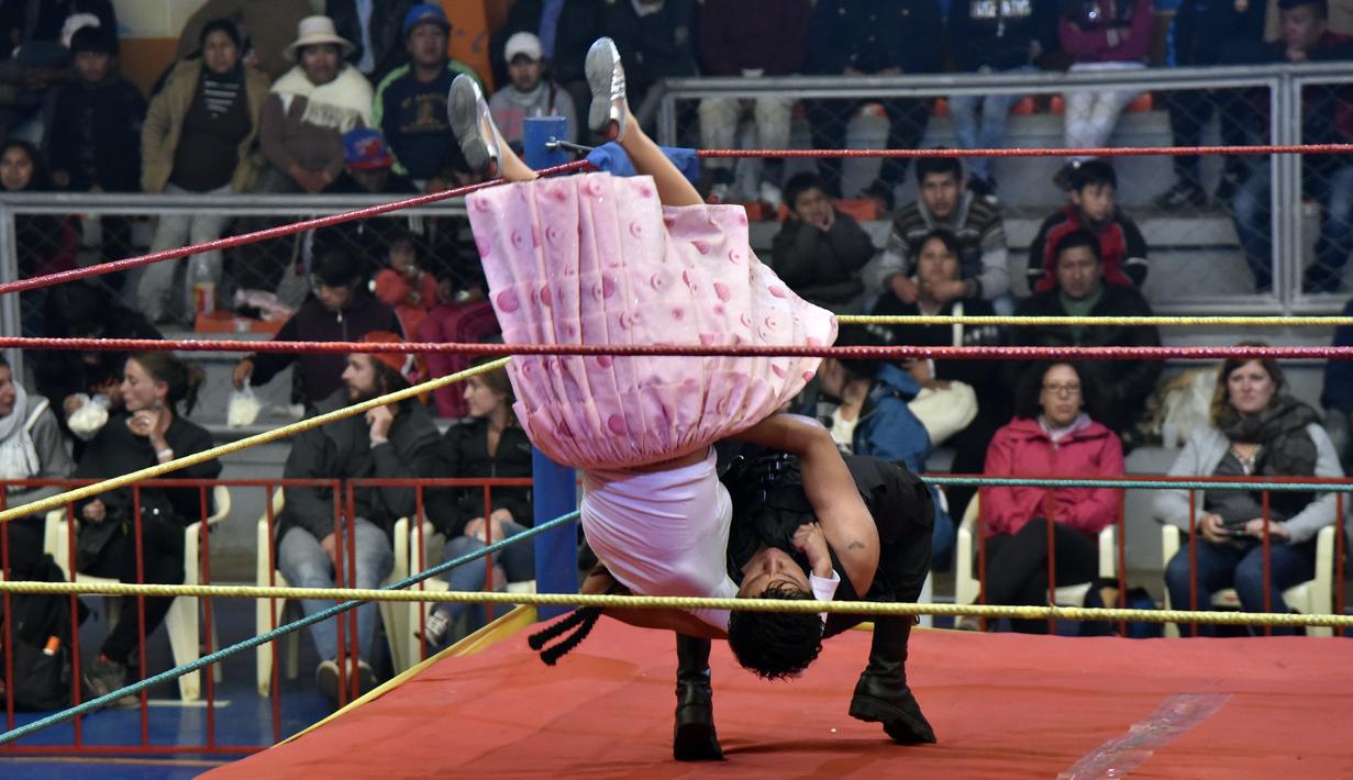"Rosita" (kanan) bertarung melawan "Comando" dalam pertandingan gulat "cholitas" (wanita Aymara yang memakai rok) di El Alto, Bolivia, (15/11/2015). Gulat "cholitas" adalah salah satu atraksi populer di masyarakat Bolivia. (AFP Photo/Aizar Raldes)