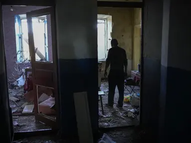 Seorang penduduk setempat mengumpulkan barang-barang dari rumahnya yang rusak berat setelah serangan Rusia di Pokrovsk, Ukraina timur, Rabu (25/5/2022). Dua roket menghantam kota Pokrovsk, di wilayah Donetsk pada Rabu pagi, menyebabkan sedikitnya empat cedera. (AP Photo/Francisco Seco)