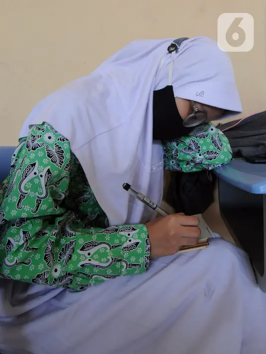 Murid melakukan kegiatan belajar tatap muka dengan penerapan protokol kesehatan COVID-19 di SMAN 2 Cibinong, Kabupaten Bogor, Jawa Barat, Rabu (17/3/2021). Sebanyak 170 sekolah di Kabupaten Bogor mulai menggelar uji coba pembelajaran secara tatap muka hingga 10 April 2021. (merdeka.com/Arie Basuki)