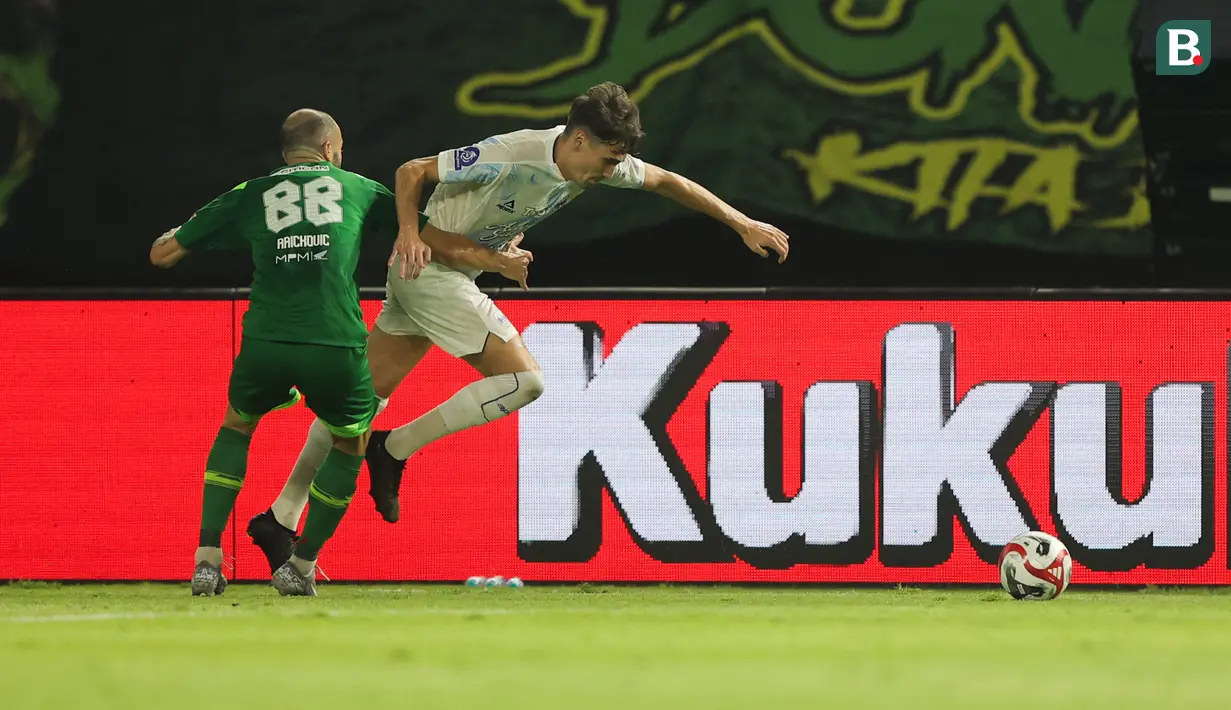 Pemain PSIM Yogyakarta, Cofre Deri Antony (kanan) berhasil melewati hadangan pemain Persebaya Surabaya pada pertandingan pembuka BRI Super League 2025/2026 di Stadion Gelora Bung Tomo, Jumat (08/08/2025) malam WIB. (Bola.com/Abdul Aziz)