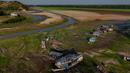 Perahu dan rumah-rumah terlihat terdampar di Danau Aleixo akibat kekeringan parah di sebelah barat Manaus, Negara Bagian Amazonas, Brasil, pada 20 September 2024. (MICHAEL DANTAS/AFP)