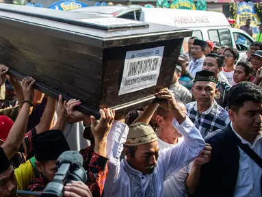 Sejumlah keluarga dan kerabat mengangkat jenazah korban jatuhnya pesawat Lion Air JT 610 Jannatun Cintya Dewi saat tiba di kediaman kawasan Sukodono, Sidoarjo, Jawa Timur, Kamis (1/11). (JUNI KRISWANTO / AFP)